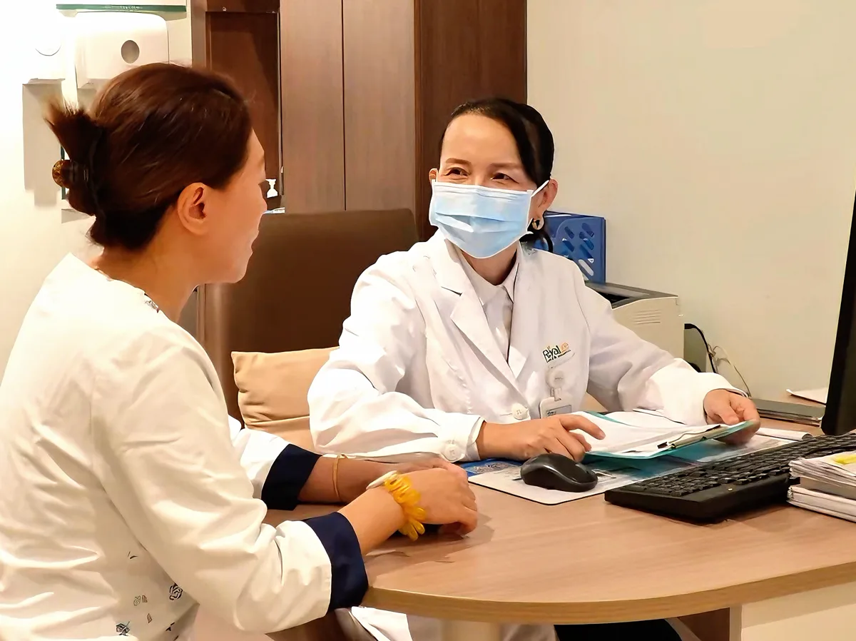 A visitor speaking with a clinician at a consultation desk
